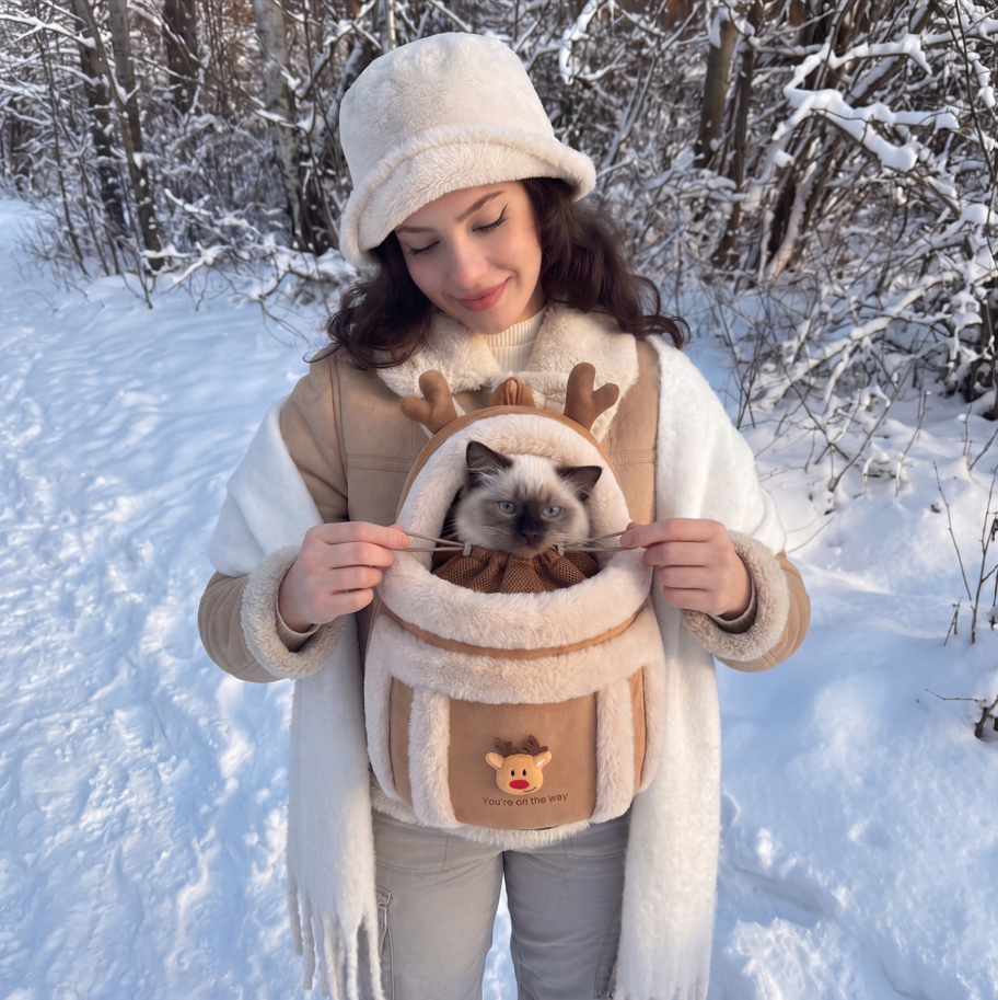 Femme dans la neige portant le sac de Noël renne, un chat blotti à l'intérieur
